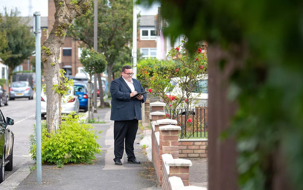 Surveyor standing outside property